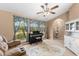 Living room with vaulted ceiling, piano, loveseat, and views of the front yard at 5105 Bannock Cir, North Port, FL 34288