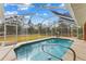 Screened-in pool with a view of the backyard, with a clear blue sky overhead at 5105 Bannock Cir, North Port, FL 34288