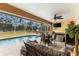 Screened-in pool area with a dining set, hot tub, and lush landscaping at 5105 Bannock Cir, North Port, FL 34288
