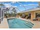 Backyard pool with a screened enclosure, hot tub, dining area, and lush green lawn at 5105 Bannock Cir, North Port, FL 34288