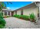 Charming backyard with gravel pathway, lush landscaping, and access to the home at 5345 Siesta Ct, Sarasota, FL 34242