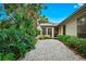 Backyard oasis featuring a gravel pathway, tropical plants, and access to the home at 5345 Siesta Ct, Sarasota, FL 34242