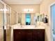 Bright bathroom featuring a double sink vanity with dark cabinets and a glass-enclosed shower at 5611 Key West Pl # 5611, Bradenton, FL 34203