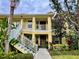 Charming yellow two-story condo building with lush landscaping and welcoming staircases at 5611 Key West Pl # 5611, Bradenton, FL 34203