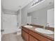 Bathroom with dual vanities, tiled shower/tub combo, and brown wood cabinets at 7005 57Th E Ter, Palmetto, FL 34221