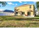 Two-story home with yellow siding, backyard patio, and white fence at 7005 57Th E Ter, Palmetto, FL 34221