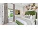 Relaxing bedroom with a green velvet headboard and plenty of light at 8020 Moonbeam Ave, Sarasota, FL 34241
