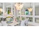 Elegant dining room with a statement chandelier and mirrors at 8020 Moonbeam Ave, Sarasota, FL 34241