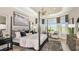 Large bedroom with bay windows and en-suite bathroom featuring white bedding and elegant furnishings at 8020 Moonbeam Ave, Sarasota, FL 34241