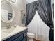 Bathroom with dark vanity, oval mirror, and shower/tub at 8334 Sailing Loop, Lakewood Ranch, FL 34202