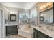 Elegant bathroom with a large soaking tub, double vanity, and grey cabinets at 8334 Sailing Loop, Lakewood Ranch, FL 34202