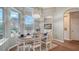 Sunlit dining area features an oval table, white chairs, and large windows at 8334 Sailing Loop, Lakewood Ranch, FL 34202