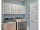 Laundry room with Samsung washer and dryer, and white cabinets at 8334 Sailing Loop, Lakewood Ranch, FL 34202