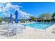 Community pool with a spa, lounge chairs, tables, and umbrellas on a sunny day at 9620 Club South Cir # 5206, Sarasota, FL 34238