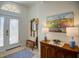 Bright foyer with decorative glass front door, a wooden bench, and a console table at 12086 Granite Woods Loop, Venice, FL 34292