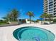 Circular hot tub surrounded by palm trees and a gate at 1211 Gulf Of Mexico Dr # 105, Longboat Key, FL 34228