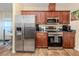 Modern kitchen with stainless steel appliances and wood cabinets at 1296 Skagway Ter, North Port, FL 34291