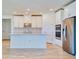 Bright, modern kitchen featuring white shaker cabinets, stainless steel appliances, and an island with quartz countertops at 14010 Ginnie Springs Way, Parrish, FL 34219