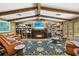 Living room with fireplace, built-in shelves, leather furniture, and wood-beamed ceiling at 1501 Peregrine Point Dr, Sarasota, FL 34231