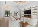 Bright living room with white furniture, large TV, fireplace, and wood floors at 1521 Bay Rd, Sarasota, FL 34239