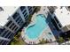 Top-down view of the kidney-shaped pool, hot tub, and apartment balconies at 1709 N Tamiami Trl # 214, Sarasota, FL 34234