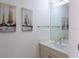 Modern bathroom with single vanity, mirror, and nautical-themed artwork at 1709 N Tamiami Trl # 214, Sarasota, FL 34234