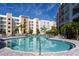 Inviting community pool with lounge chairs and surrounding palm trees at 1709 N Tamiami Trl # 214, Sarasota, FL 34234
