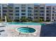 Resort-style pool and spa with a modern apartment building in the background at 1709 N Tamiami Trl # 214, Sarasota, FL 34234