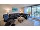 Living room with leather sectional and access to balcony at 1935 Gulf Of Mexico Dr # G7-302, Longboat Key, FL 34228