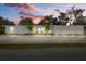 Charming single-story home with a bright white exterior, well-manicured lawn, and beautiful landscaping at 2069 Bougainvillea St, Sarasota, FL 34239