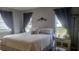 Bedroom with king-size bed, nightstands, curtains, and view of the backyard at 214 Genet Ct, Sun City Center, FL 33573