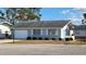 Charming single-story home with a gray exterior, attached garage, and landscaped front yard at 214 Genet Ct, Sun City Center, FL 33573
