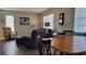 Living area with leather couches, recliner, wooden dining table, and decorative wall clock at 214 Genet Ct, Sun City Center, FL 33573