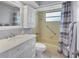 Well-lit bathroom with a vanity, cabinet, and tiled shower/tub combination at 2835 N Beach Rd, Englewood, FL 34223