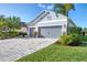 Lovely front exterior with a two-car garage, charming light fixtures, and lush landscaping at 3405 Box Turtle Ter, Parrish, FL 34219