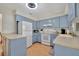 Bright kitchen with light blue cabinets, white appliances, and light countertops at 409 Archibald Ave, Sarasota, FL 34243