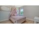 bedroom with canopy bed, pink bedding, and window view at 5714 Broad River Run, Ellenton, FL 34222