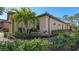 Side view of a home with a tiled roof, gutters, and well-maintained shrubs at 5737 Semolino St, Nokomis, FL 34275