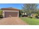 Inviting front yard with a paved driveway, attached garage, and lush landscaping at 5737 Semolino St, Nokomis, FL 34275