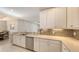 Modern kitchen boasts white cabinets, stainless steel appliances, and ample counter space at 5737 Semolino St, Nokomis, FL 34275