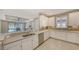 Modern white kitchen with stainless steel appliances, breakfast bar, and open view at 5737 Semolino St, Nokomis, FL 34275