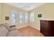 Cozy bedroom with a ceiling fan, couch, and arched windows with shutters at 616 Misty Pond Ct, Bradenton, FL 34212