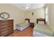 Bedroom with two twin beds, a dresser, and plantation shutters on the window at 616 Misty Pond Ct, Bradenton, FL 34212