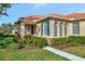 Exterior view of a home's arched windows, green shutters, and landscaped walkway at 616 Misty Pond Ct, Bradenton, FL 34212