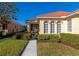 Front walkway and entrance to the home, featuring arched windows and manicured shrubs at 616 Misty Pond Ct, Bradenton, FL 34212