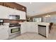 Modern kitchen with stainless steel appliances, white cabinets, and tile flooring at 616 Misty Pond Ct, Bradenton, FL 34212