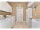 Laundry room with white cabinets, washer, dryer, and folding counter at 616 Misty Pond Ct, Bradenton, FL 34212