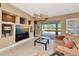 Living room with built-in entertainment center, sliding glass door to patio, and ceiling fan at 616 Misty Pond Ct, Bradenton, FL 34212