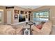 Inviting living room featuring an entertainment center, ample seating, and views of the pool at 616 Misty Pond Ct, Bradenton, FL 34212