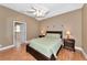Main bedroom with wooden bedframe, ceiling fan, and view of the ensuite bathroom at 616 Misty Pond Ct, Bradenton, FL 34212